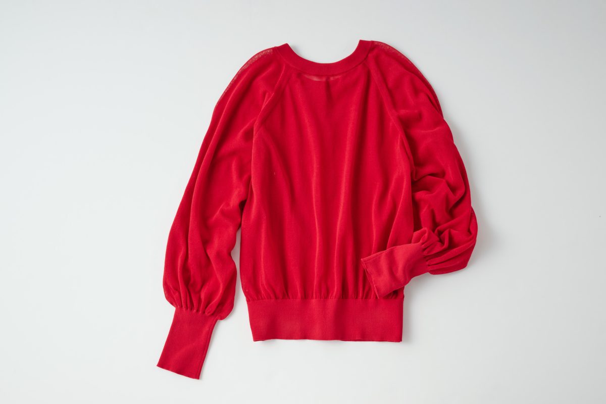 シアー2WAYニット 19,800円（3F〈ガリャルダガランテ〉で販売中） 表はボタンを外してトップスとレイヤードしたり、裏はパンツにインしてさらっと着たり、チェンジして楽しめる。程良いシアー感と旬の赤で女性らしさを演出。