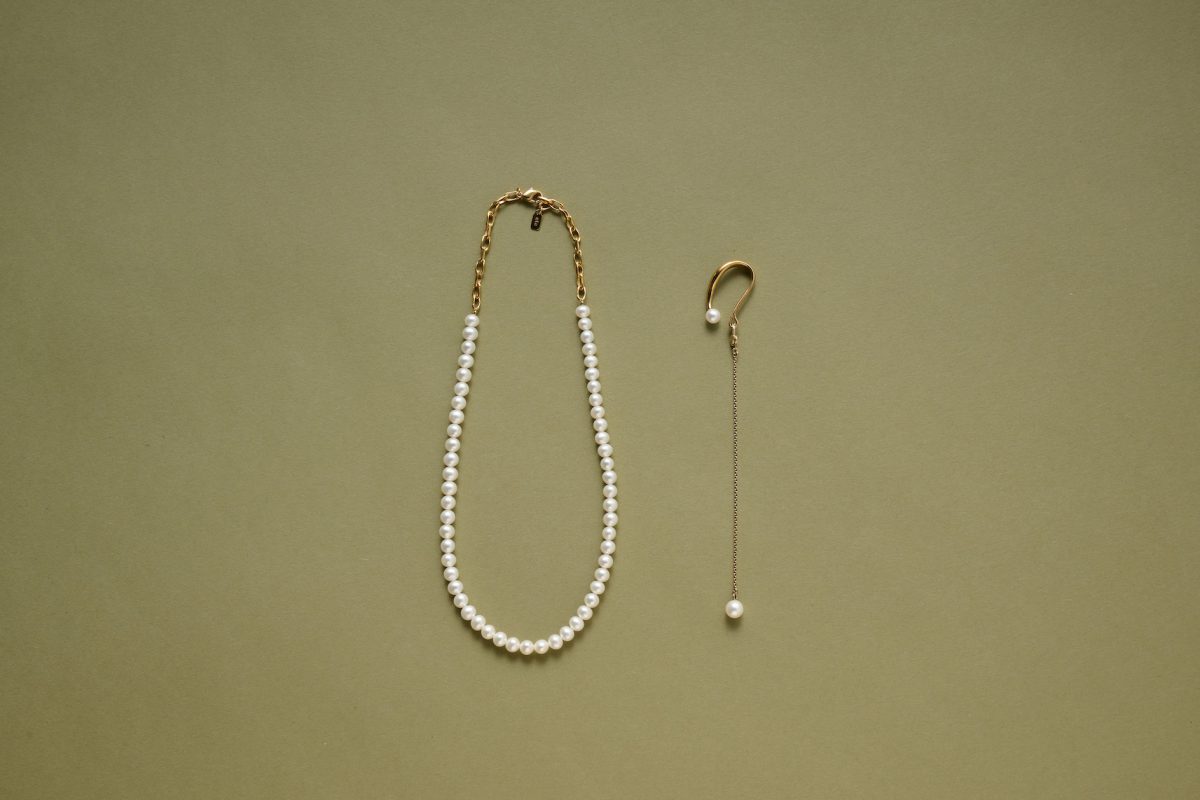 左から、パールネックレス 25,300円（4F〈ete〉で販売中）　イヤリング 13,200円（Jouete／3F〈Jouete ADDITION〉で販売中） ワントーンコーデに合わせて、ジュエリーはシンプルかつクラシカルなパールで統一。耳に引っ掛けるタイプのイヤリングは、揺れるタイプでさりげない主張を。