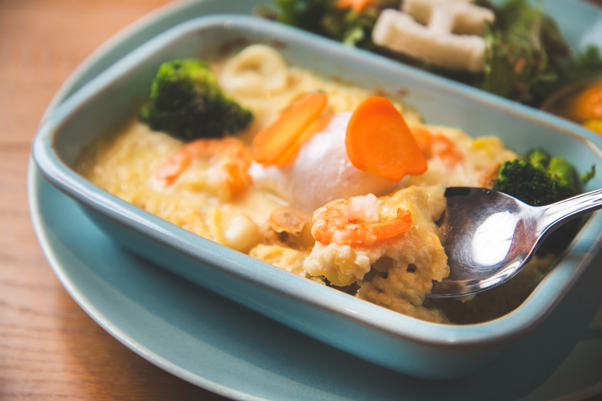 渋谷ヒカリエの〈Disney HARVEST MARKET By CAFE COMPANY〉の「あつあつ！クリームシーフードドリアと真っ白ポーチドエッグ」