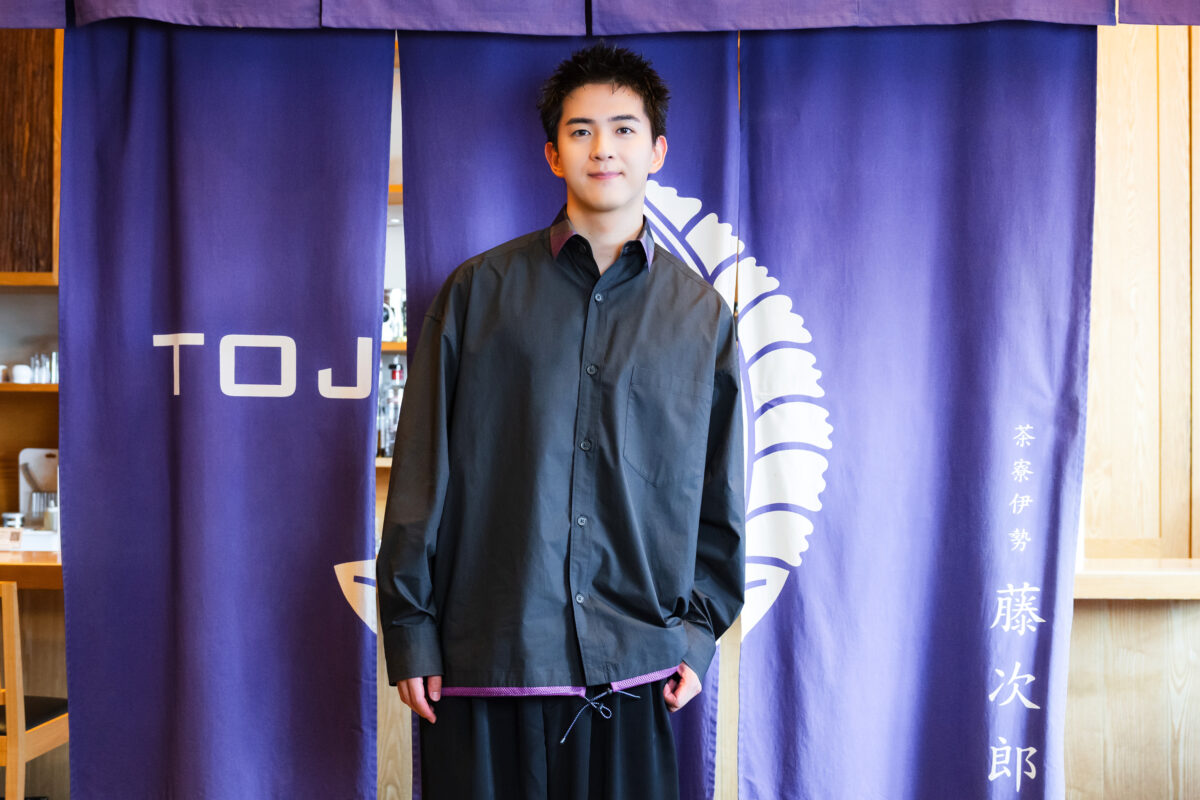 〈茶寮伊勢 藤次郎〉の暖簾の前に立つ俳優・甲斐翔真さん